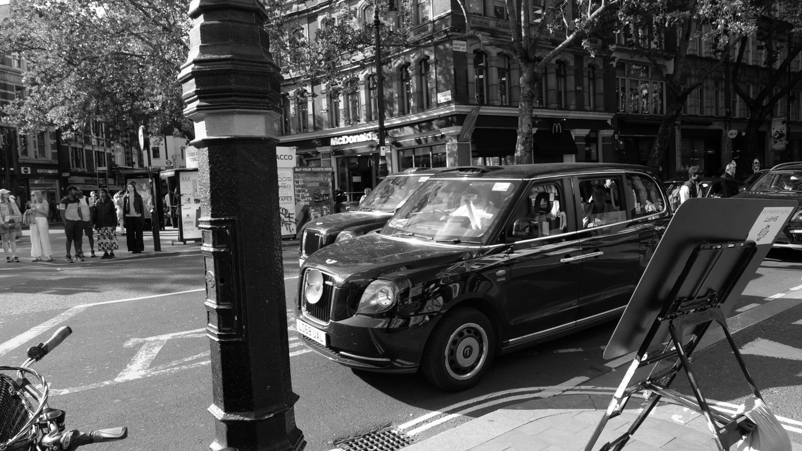 a black and white photo of a car parked on the side of the road